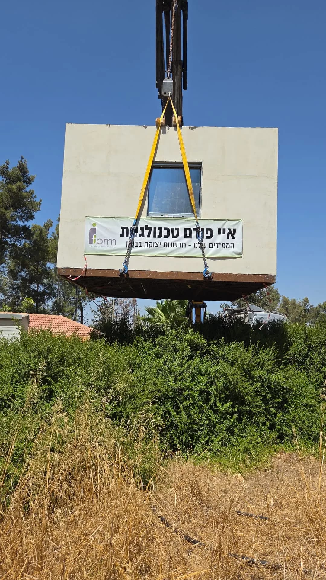 מודול ממ"ד של Iform ביצוע מונף באתר בעזרת מנוף, עם שילוט החברה על הדופן