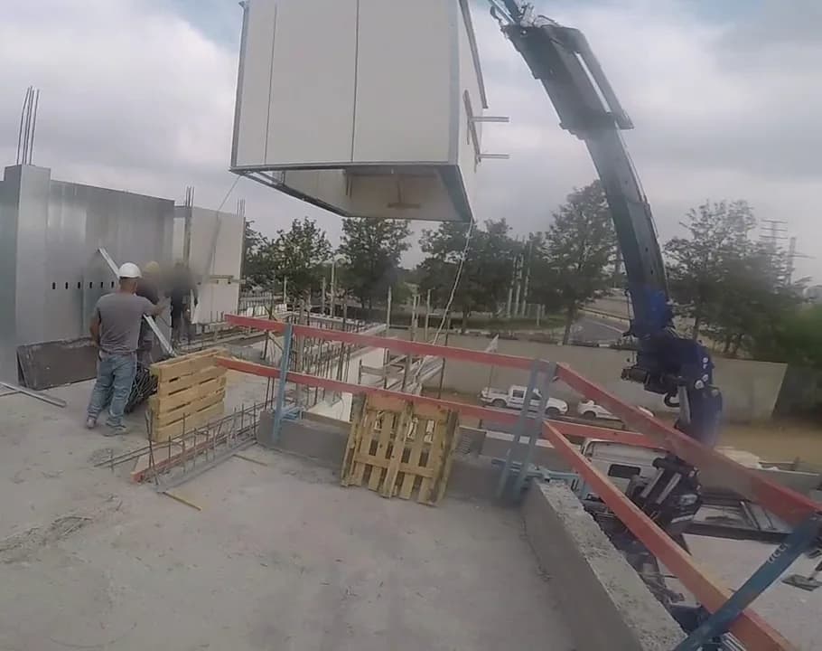 אלמנט מערכת iForm מורד במנוף אל הגג, ליד קירות תבנית פלדה שכבר הורכבו, בניין מגורים ברעננה